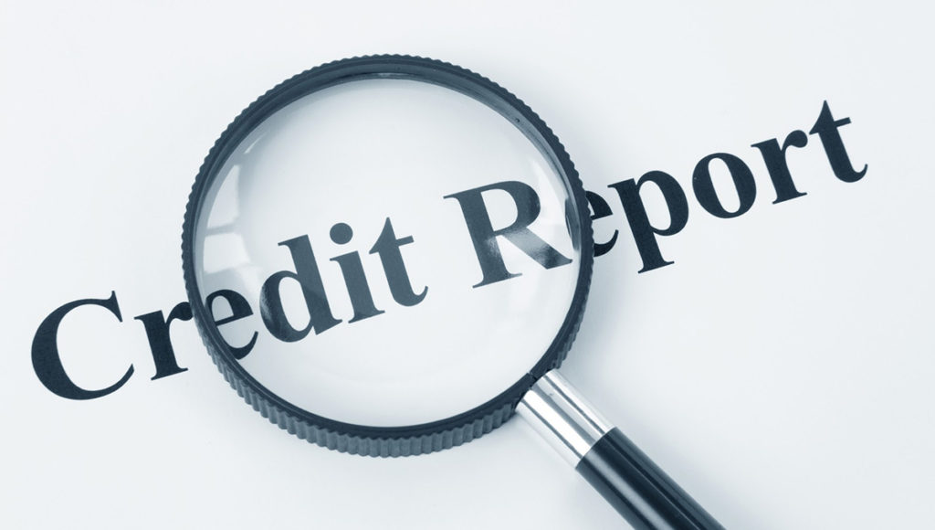 magifying glass inspecting credit report